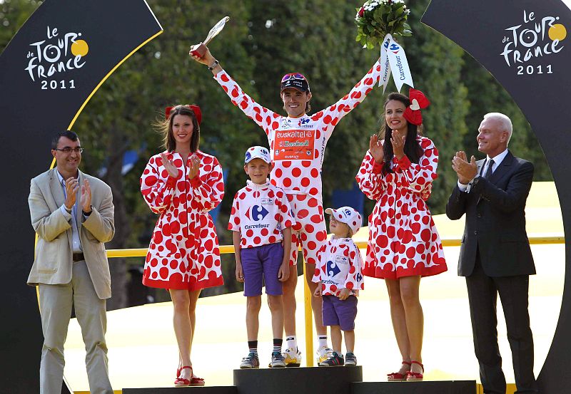 El ciclista español del Euskaltel Euskadi, Samuel Sánchez, celebra junto a sus hijos y el director de la Vuelta a España, Javier Guillén, quien le colocó el maillot de lunares, el triunfo en la clasificación de la montaña en los Campos Elíseos de Par