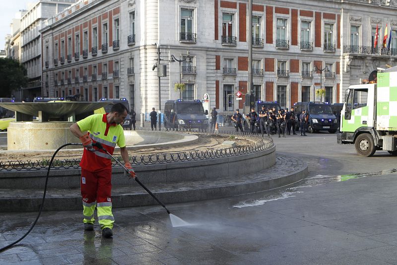 Los servicios de limpieza recogen los residuos del campamento de los indignados