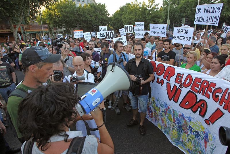 Varios indignados muestran su pancarta durante la protesta del movimiento 15M iniciado en la plaza de Atocha, en Madrid.