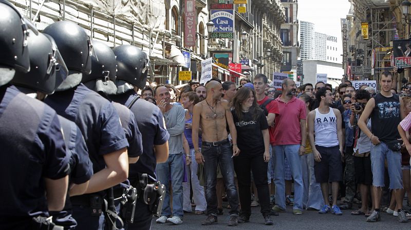 La marcha de "indignados" que partió este mediodía de la plaza de Oriente de Madrid retenida en la carrera de San Jerónimo donde el dispositivo policial impide su acceso a la Puerta del Sol.