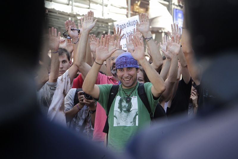 "Indignados" levantan las manos ante el dispositivo policial que les impide acceder a la Puerta del Sol desde la carrera de San Jerónimo en una marcha que partió este mediodía de la plaza de Oriente.