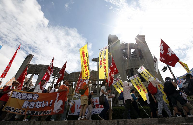 Protesters walk around the gutted Atomic Bomb Dome as they march at anti-nuclear rally in Hiroshima