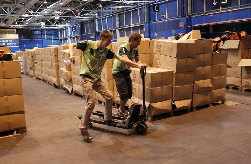 Dos voluntarios apilan material en uno de los pabellones del recinto ferial de IFEMA