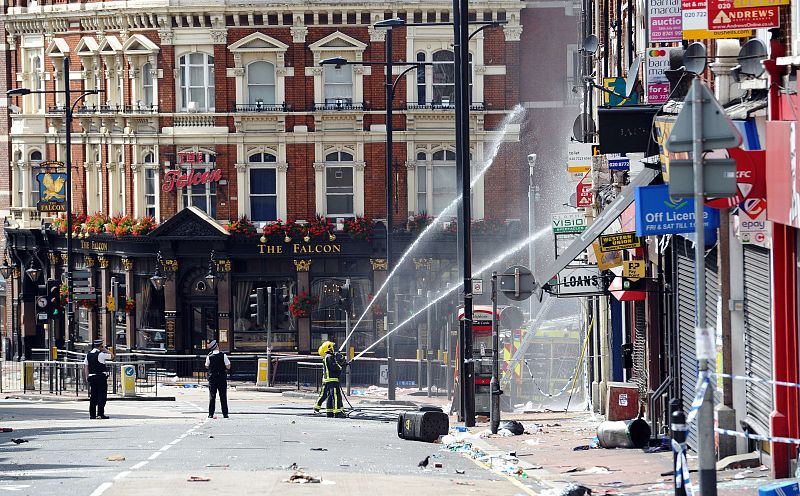 Bomberos tratan de apagar un edificio incendiado por los manifestantes en Clapham Junction, al sur de Londres.