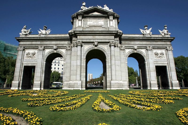 Flores blancas y amarillas, los colores vaticanos, en los jardines que rodean la madrileña Puerta de Alcalá, para recibir al Papa Benedicto XVI