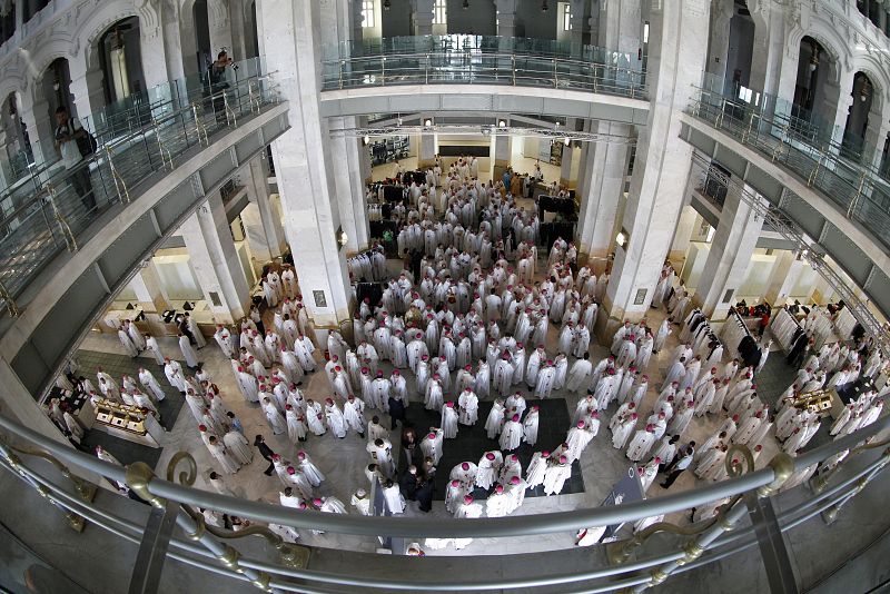 Varios sacerdotes se preparan en el interior del Ayuntamiento de Madrid, para la misa de bienvenida de los peregrinos