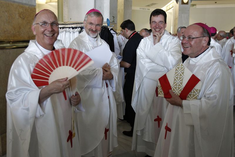 Varios sacerdotes se abanican en el interior del Ayuntamiento antes de asistir a la misa de bienvenida a los peregrinos