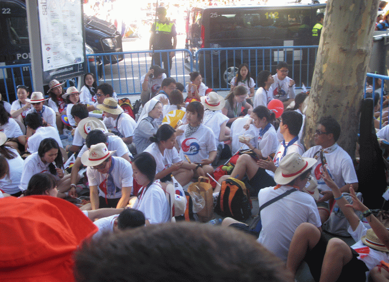 Peregrinos Coreanos descansan cerca de la Puerta de Alcalá