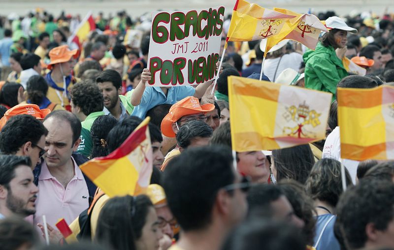 Gran número de personas ondean banderas y muestran pancartas en el aeropuerto de Barajas a la espera de la llegada del papa Benedicto XVI