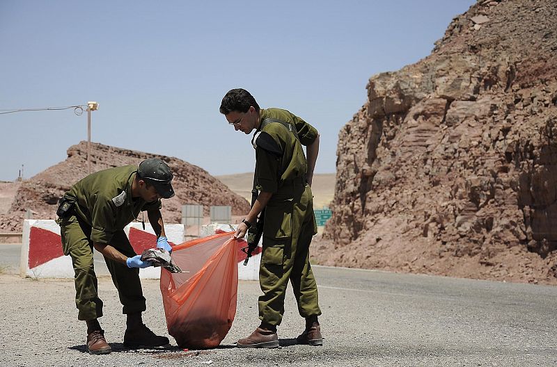 Soldados israelíes recogen ropas manchadas de sangre en el lugar del atentado