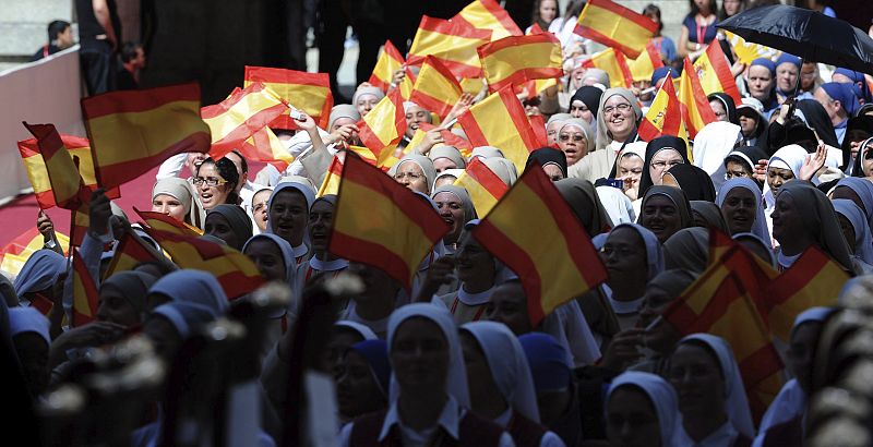 Jóvenes religiosas sostienen banderas españolas durante su encuentro con el papa Benedicto XVI