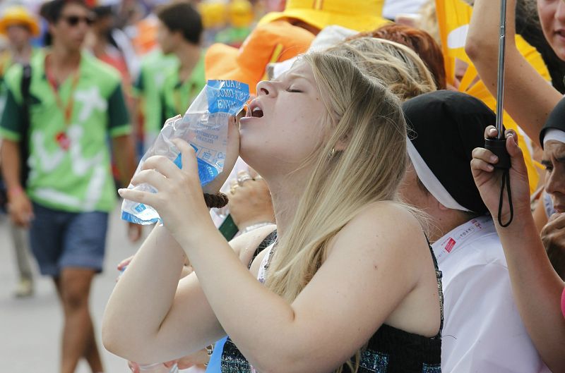 Una joven se refresca en la plaza de Cibeles de la capital antes de la llegada del papa Benedicto XVI