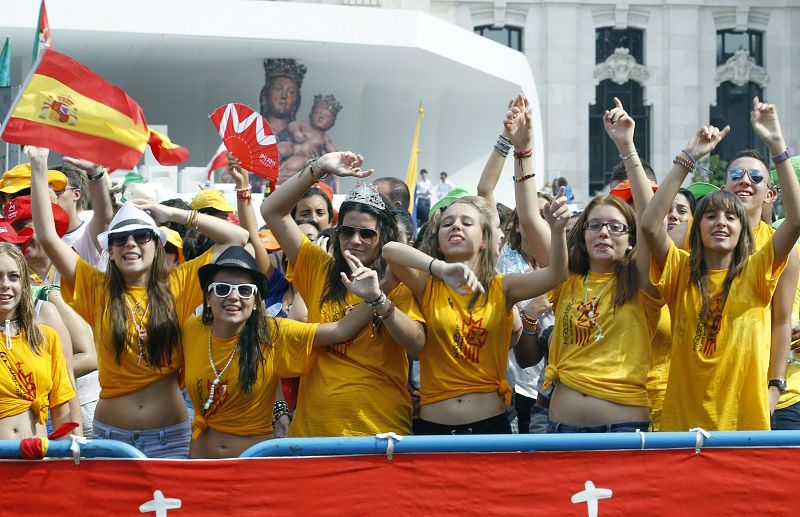Varios jóvenes esperan la llegada del papa Benedicto XVI en la plaza de Cibeles