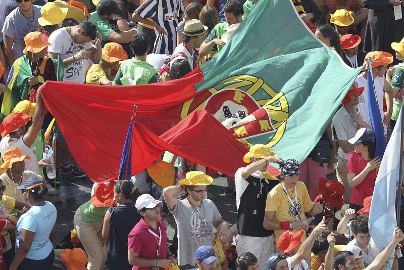 Peregrinos portugueses ondean una bandera de su país mientras esperan de la llegada de Benedicto XVI