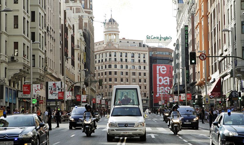 El papa Benedicto XVI, a bordo del papamóvil, a su paso por la Gran Vía madrileña durante el recorrido que ha realizado hasta la catedral de La Almudena.
