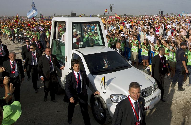 El papa Benedicto XVI saluda desde el papamóvil durante el recorrido que ha realizado por el aeródromo de Cuatro Vientos