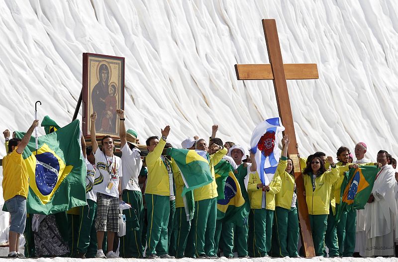 Peregrinos brasileños llevan la Cruz durante la misa