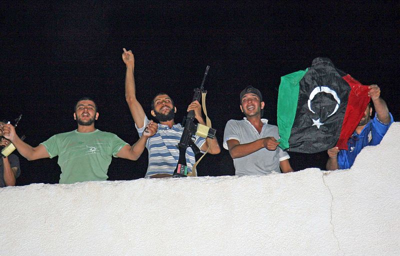 Los rebeldes de trípoli suben a los edificios con banderas continuando con la celebración