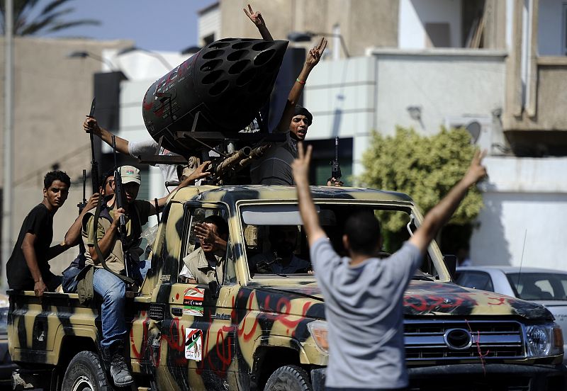 Rebeldes libios conducen por las calles de Trípoli hoy martes, 23 de agosto
