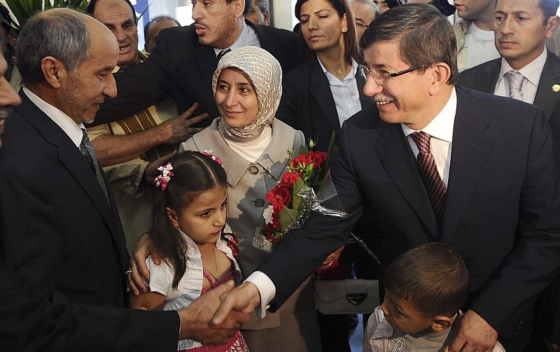El ministro turco de Exteriores, Ahmet Davutoglu, saluda al líder del Consejo Nacional de Transición libio (CNT), durante la rueda de prensa conjunta