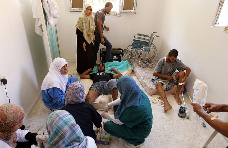 Dos hombres reciben asistencia médica después de haber resultado heridos durante los enfrentamientos en Bab al Aziyah, en Trípoli.