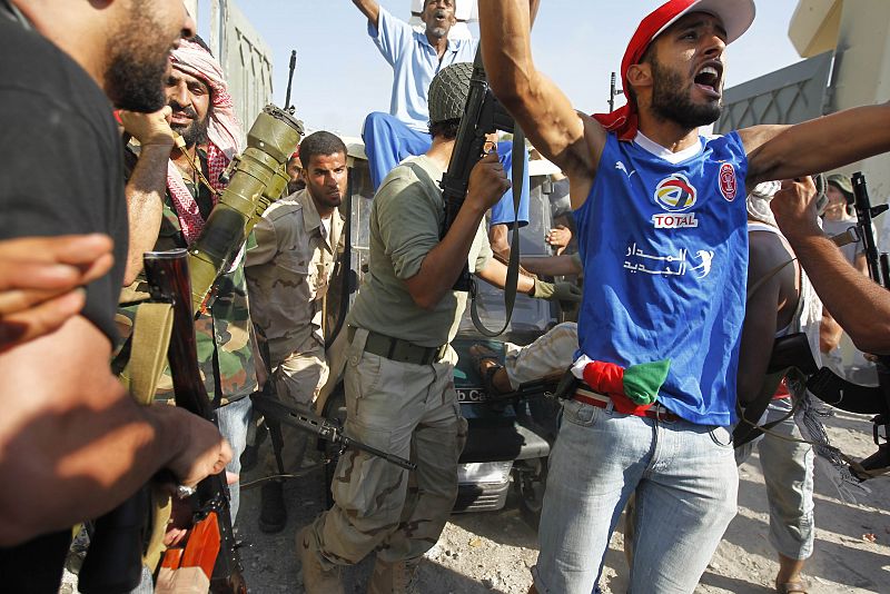 Los rebeldes celebran la toma de la residencia de Gadafi en la entrada de Bab al Aziziya.