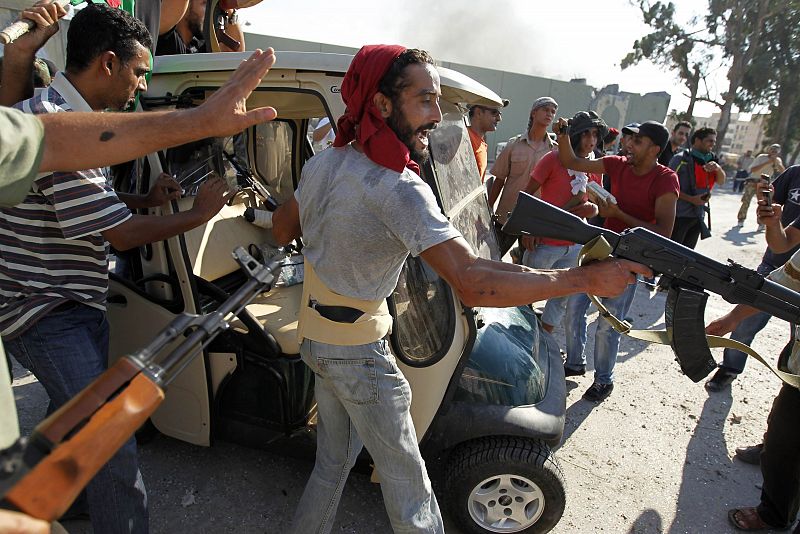 Los rebeldes celebran en la entrada de Bab al Aziziya, junto a un carro de golf perteneciente a Gadafi.