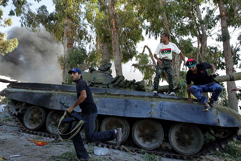 Rebeldes libios saltan de un tanque en los alrededores de Bab al Aziziya.