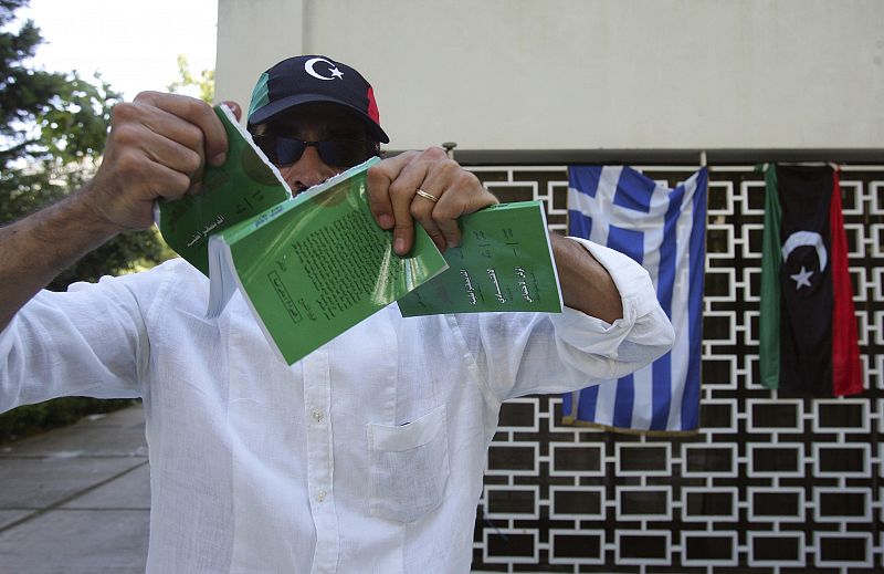 Un libio residente en Grecia destruye una copia del Libro verde de líder libio, Muammar Gadafi, en la Embajada de Atenas, Grecia.