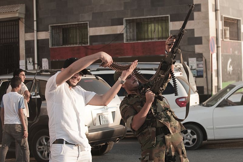 Un rebelde libio dispara al aire durante la celebración en Bengazi de la toma del palacio de Gadafi.