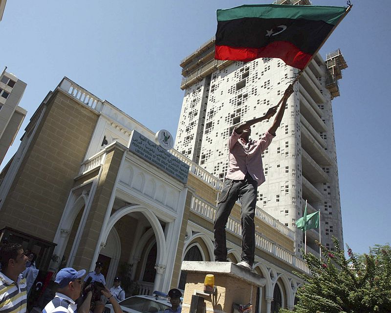 Un simpatizante libio ondea una bandera del Reino de Libia dentro de la embajada libia en Nicosia (Chipre)