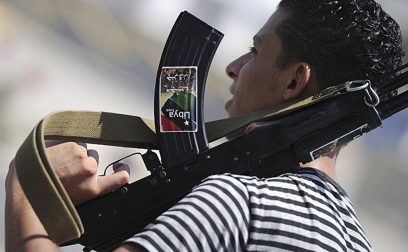 Un combatiente rebelde con su arma en una calle de Tripoli, Libia