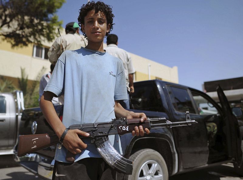 Un joven combatiente rebelde posa con su arma en una calle de Tripoli