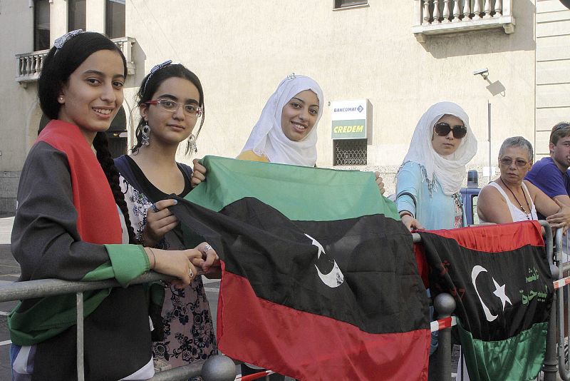 Mujeres libias favorables a las fuerzas rebeldes ondean la bandera tricolor anterior al golpe de Estado de 1969