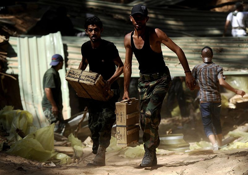 Rebeldes libios transportan munición escondida por los leales a Gadafi en el bosque al-Maser (suroeste de Trípoli)