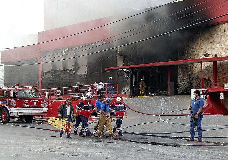 Un grupo de bomberos traslada a uno de los heridos en el ataque