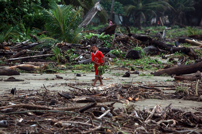 Un niño camina entre los escombros tras el paso del huracán "Irene" en Dominicana