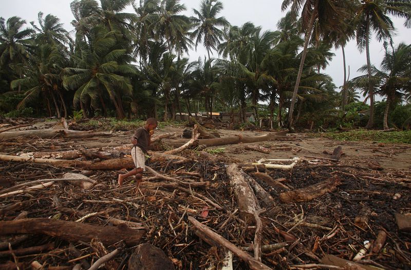 Un niño camina entre los escombros tras el paso del huracán "Irene" en la playa de Boba, República Dominicana