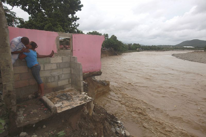 Una pareja se besa en una casa destruida por las lluvias del huracán "Irene" en San Cristóbal, República Dominicana