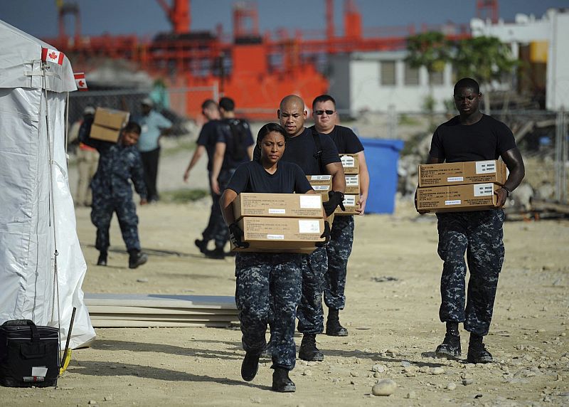 Marineros embarcando medicamentos en previsión de mal tiempo por el huracán "Irene" en Puerto Príncipe, Haití