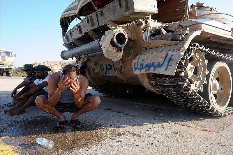 Un rebelde refresca su rostro en la parte trasera de un tanque tomado en el enclave petrolero de Ras Lanuf (Libia)