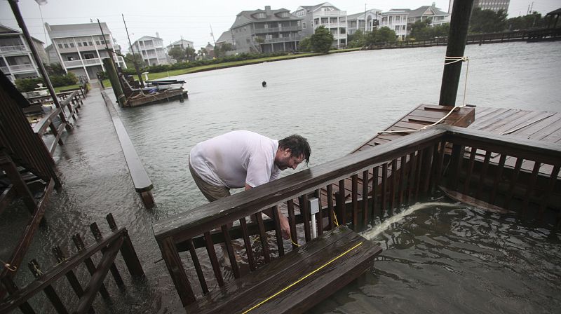 Un hombre trabaja para asegurar su muelle en Wrightsville Beach, Carolina del Norte.