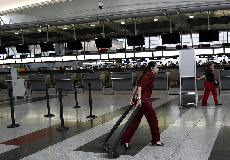 Ticket agents remove the stanchions which form the ticketing lines at JFK International Airport as the city prepare for Hurricane Irene to hit in New York