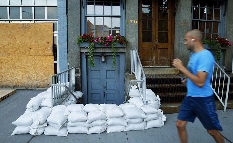 A pedestrian passes next to sandbags used to control possible floods at downtown Manhattan in New York