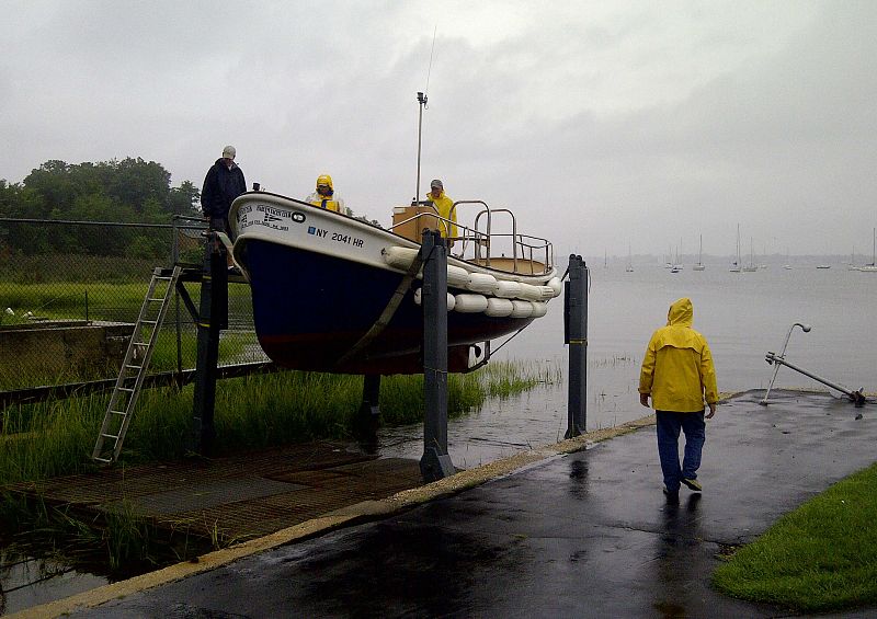 Members of the Harlem Yacht Club remove the club launch from the water in New York prior to Hurricane Irene