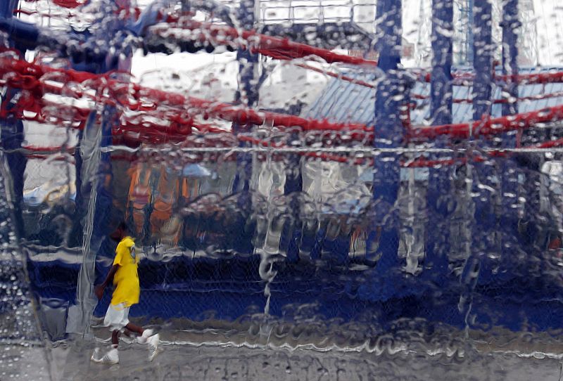 A man walks past an amusement park ride on Coney Island, ahead of Hurricane Irene's landfall in New York