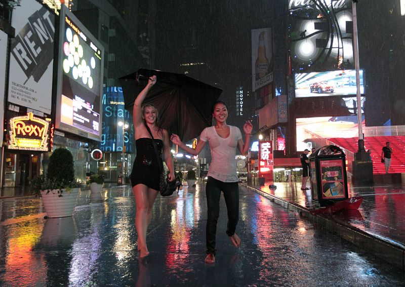 Dos jóvenes bailan bajo la lluvia que ha dejado 'Irene' al llegar a Nueva York.