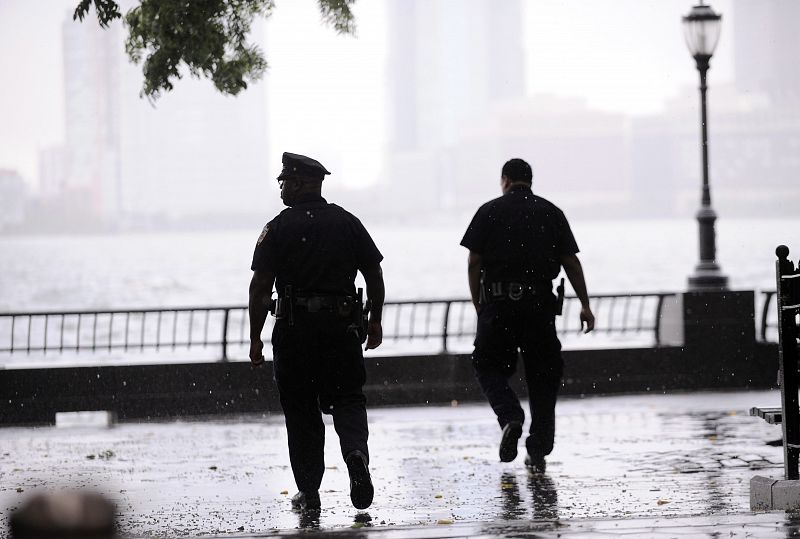 Unos policías patrullan por el puntal de Battery Park en Nueva York ante la llegada del huracán 'Irene'