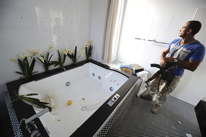 Un rebelde libio inspecciona el interior de la casa del hijo de Gadafi
