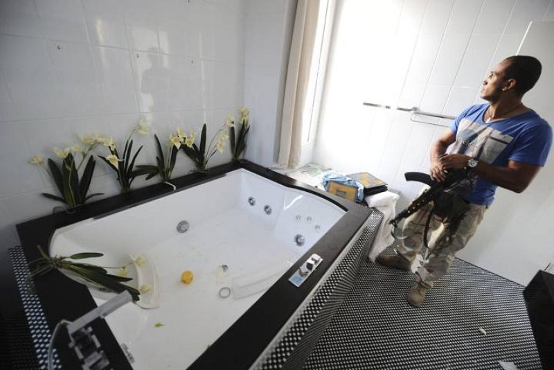 Un rebelde libio inspecciona el interior de la casa del hijo de Gadafi